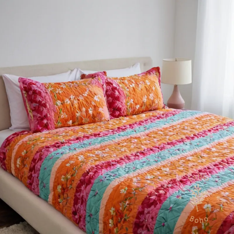 A colorful, flowy bedspread with floral pattern on a single bed.