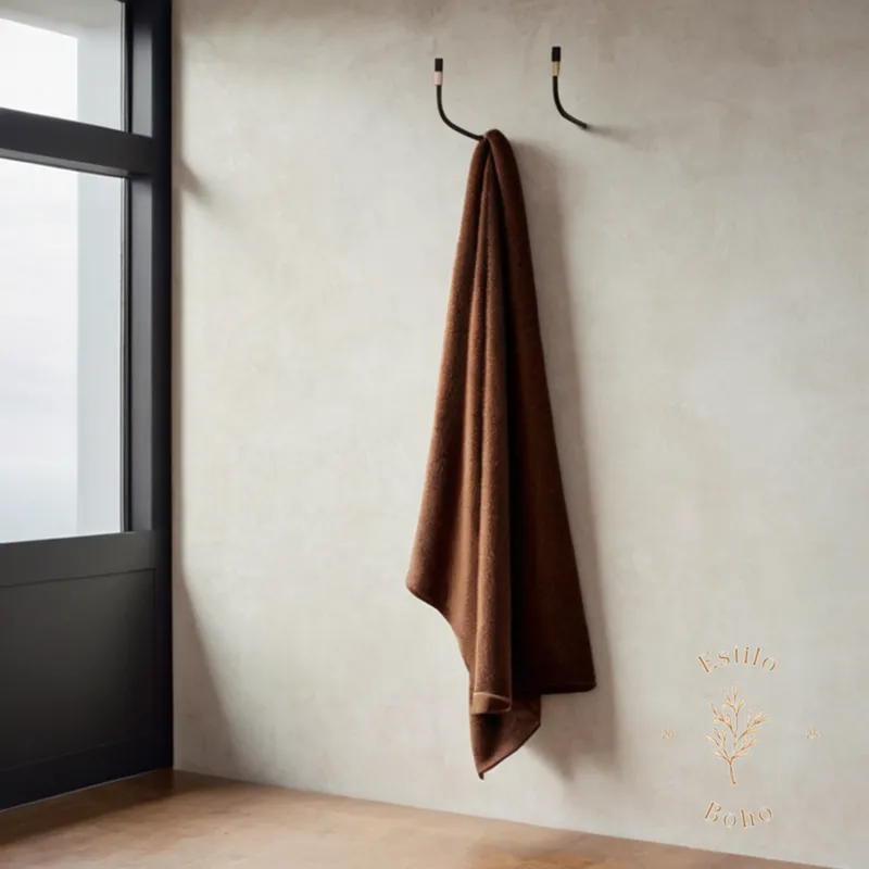 A stylishly draped alpaca throw blanket on a minimalist wall hook.